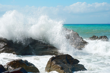 Fototapeta na wymiar Sea waves are bouncing hard onto rocks.