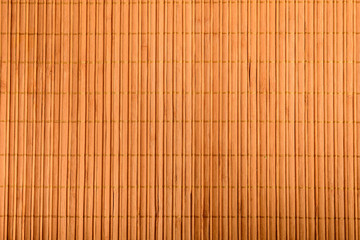 Top view of textured bamboo wooden background on a table in warm light,brown monochrome indoor background photographed with selective focus