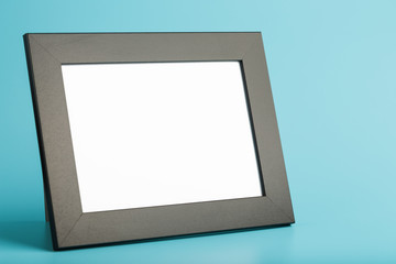 Black photo frame with free space on a blue background.