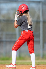 Obraz premium Girl Fastpitch Softball player in action during a competitive game