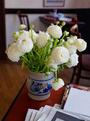 Ranunculus bouquet in vase in cafe room in Heidelberg Germany