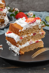 Strawberry cake, strawberry sponge cake with fresh strawberries and sour cream on a dark background