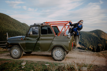 young woman on top of the mountain. extreme mountain jeep riding