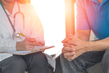 Doctor physician consulting with male patients in hospital exam room. Men's health concept