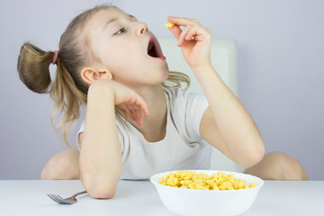 beautiful little girl at the white Breakfast cereal table