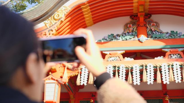 Young Asian Woman Taking Photo Of Traditional Japanese Shrine Her Smartphone. 4K Tourism Concept Footage. 6 DEC 2019 - Kyoto, Japan. 