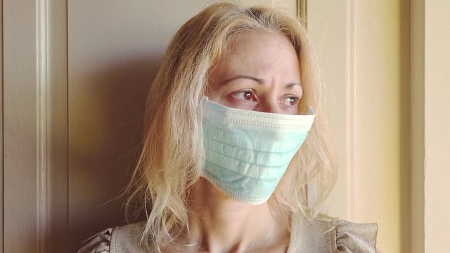 Woman with a sanitary mask on her face in slow motion. Concept of the epidemic outbreak, quarantine for public health care and infections of the corona-virus.