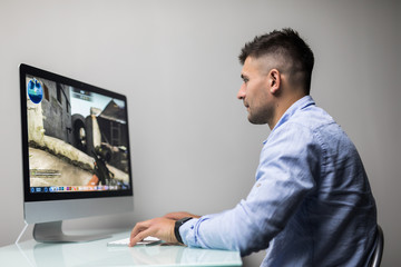 Professional gamer playing in first-person shooter online video game on his personal computer.