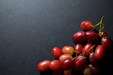 red grapes in the bottom right corner view from above on a black background with copy-country horizontal orientation