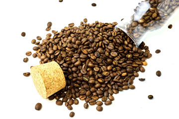 scattered coffee beans from glass bottle and cork isolated on white