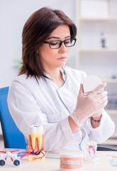 Woman dentist working on teeth implant