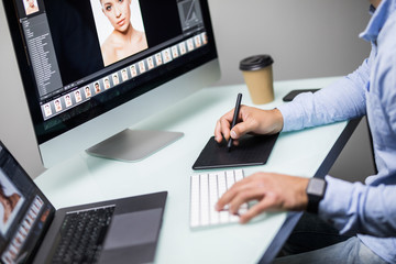 Hand of male designer working at his desk using stylus and digital graphics tablet.