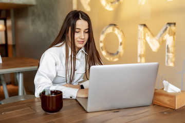 Beautiful brunette browsing internet on personal laptop
