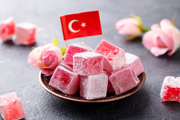 Turkish delight, rose flavour in a copper plate with Turkish flag. Grey background. Close up.