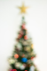 Defocused christmas background. Christimas tree, star, decoration and lights 