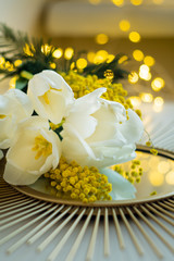 Fototapeta na wymiar Bouquet of white tulips and mimosa flowers on mirror tray