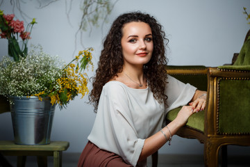 beautiful girl model with curls in a dress posing in beautiful arrangements. The beginning of...