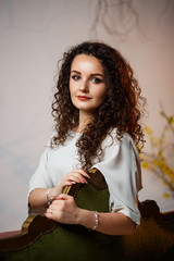 beautiful girl model with curls in a dress posing in beautiful arrangements. The beginning of...