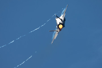 F-35 Lightning II in a tight turn, with afterburner on and condensation trails at the wing’s tips