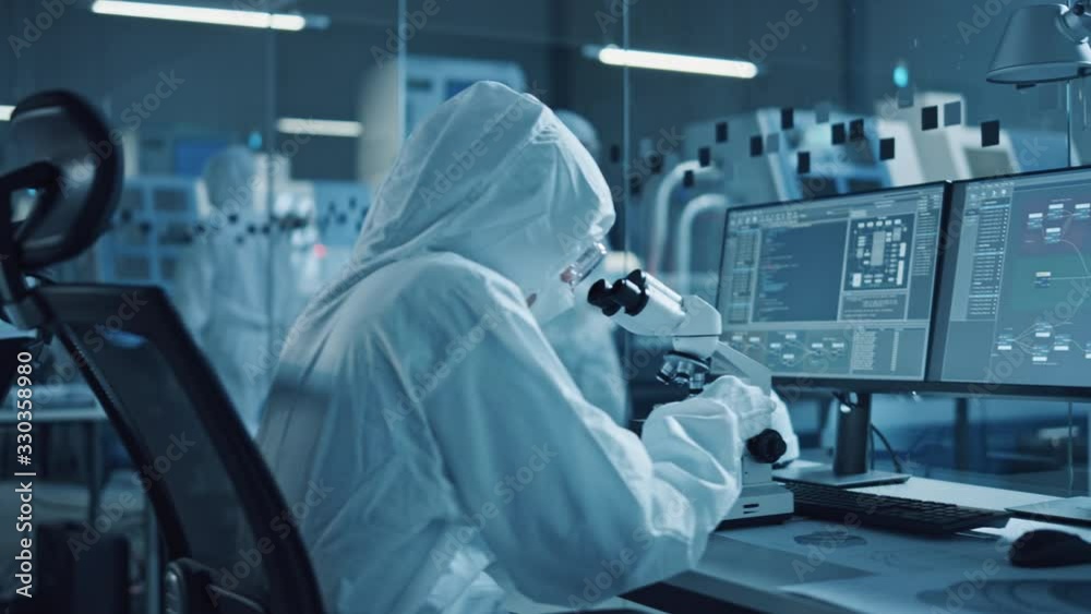 Poster modern factory: team of engineers and scientists in clean sterile coveralls work on desktop computer