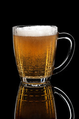 glass of draft lager beer on black table