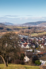 Little village in the middle of the german countryside with hills, forests, fields and meadows