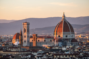 Fototapeta na wymiar A giant cathedral with a dome glows in the sunset of Florence