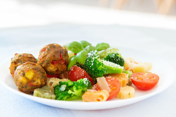 Healthy vegetarian noodles with broccoli cherry tomato and falafel