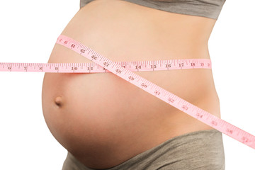 Pregnant girl measures waist circumference with a tape