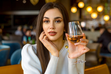 Beautiful girl holding a glass of vine.