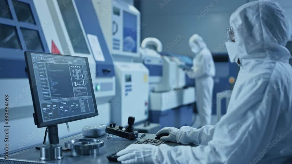 Aufkleber factory cleanroom: engineer wearing coveralls does system control on a computer, uses controller, sc