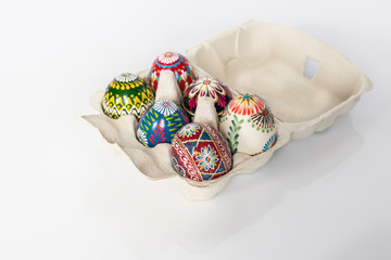Colorful Easter eggs in a carton on a white background