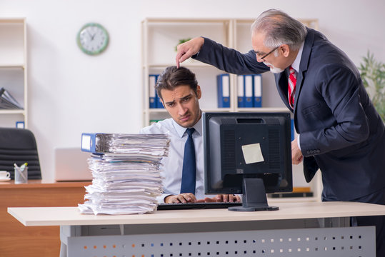 Old boss and young male employee in the office