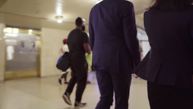 Business woman and man leaving work heading home Grand Central Station during rush hour