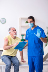 Injured old man visiting young male doctor traumatologist