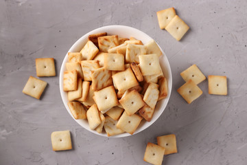 Cracker cookies in a white ceramic bowl on a gray background, Top view