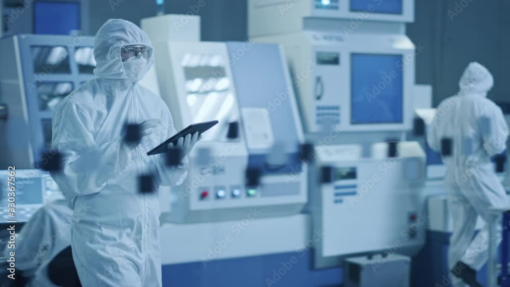 Poster research factory cleanroom: engineer wearing coverall and mask, walking through workshopop uses tabl