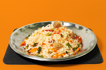 plate of homemade fried rice recipe with vegetable slice isolated on orange background