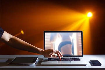 a young caucasian man lying on the couch watches porn in his tablet computer
