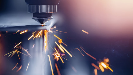 CNC gas cutting metal sheet, sparks fly. Blue steel color, modern industrial technology