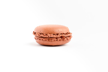Side view of one sweet vivid brown chocolate French macaron isolated on white background, tasty...
