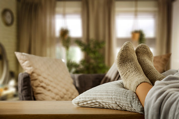 Woman legs with socks and wooden table of free space for your decoration..Home interior. 