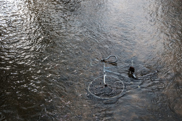 Steel bicycle strown into the river is pollution for environment
