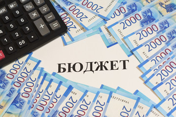 Estimates of income and expenses. Calculator, cash and Russian text of "the Budget"