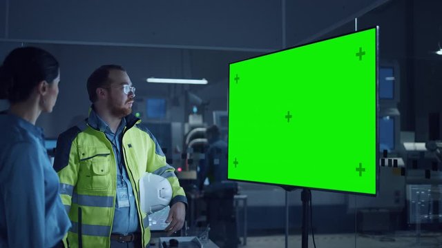 Office Meeting: Confident Female Project Manager to Chief Engineer, Watching Interactive Digital Whiteboard TV that Shows Green Screen Chroma Key Display. Modern Factory. Slow Motion Gestures