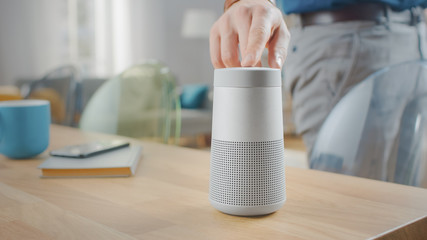 Man Turns On Smart Speaker that Activates Artificial Intelligence Assistant.