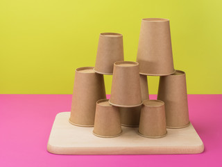 Disposable tableware in pink and light green background.