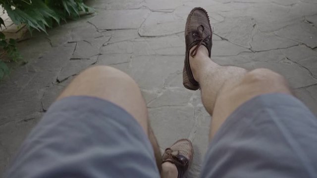 A man in shorts rides on a swing first-person view