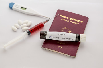 Covid-19 test result on turkish passport with syringe, thermometer, and pills