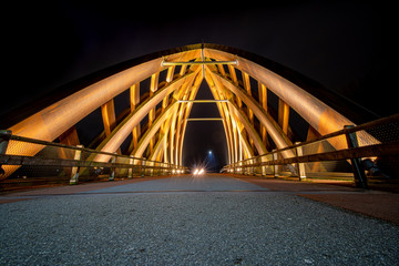 Wooden traffic bridge in the evening with illuminated curved lines and high-up perspective
